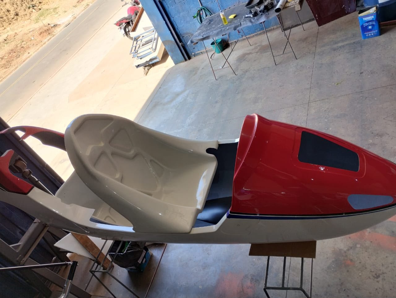Casco bege de girocóptero com capô de motor vermelho recém-pintado